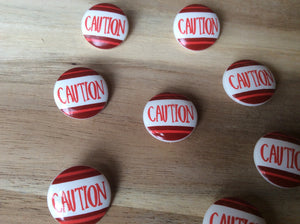 Caution button.   Price per button